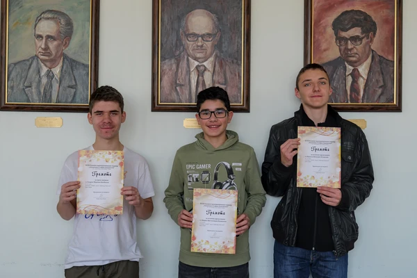 Три момчета, държащи грамоти за есенния турнир по математика.