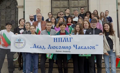 Ученици на НПМГ зад бял банер с училищното лого и име.
